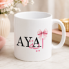 White Ayat personalized name mug with black lettering, pink calligraphy-style artwork and pink bow